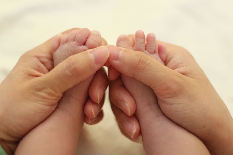 Mãos de Uma Mãe Limpando Pé do Bebê